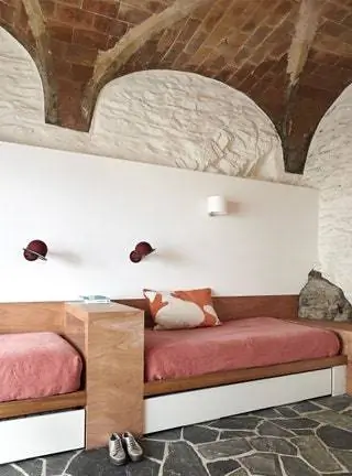 На первом этаже со встроенным диваном-кроватью и тканями Güell Lamadrid вы можете увидеть части скалы, на которой был построен дом