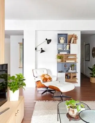 В углу гостиной кресло для отдыха от книжной полки Eames de Vitra и нестандартная решетка, разработанная Deleite Design…