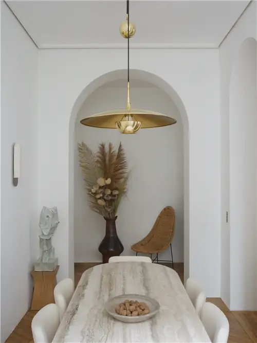 В столовой вокруг стол из травертина, деревянные стулья и винтажная ткань Thonet. На деревянном табурете…