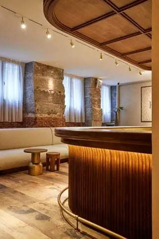 Все начинается в «Glow Lounge», большом зале ожидания с элегантной деревянной стойкой с планками…