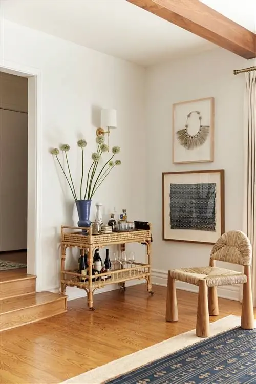 Барная тележка из ротанга от Universal Furniture и кресло из тика и тростника от Lulu Georgia составляют угол…