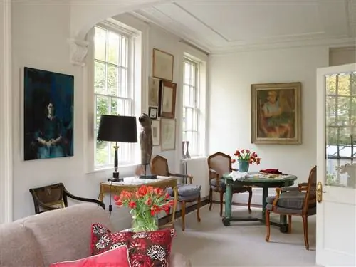 Вид на гостиную в неоклассическом стиле со стульями из черного дерева и сусального золота