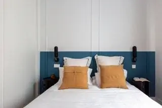 Постельное белье Zara Home, прикроватные тумбочки Componibile от Kartell и настенный светильник от Aromas del Campo