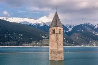 Башня церкви 1355 года возвышается над водой озера, создавая красивый образ с мрачной историей…