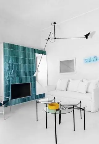 В гостиной камин с плиткой в стиле острова, диван Ghost от Paola Navone для Gervasoni и сделанные на заказ журнальные столики с…