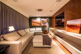 В домашнем кинотеатре диван от Artefacto, ковер от Kamy, шторы от Flax, камин от Construflama…
