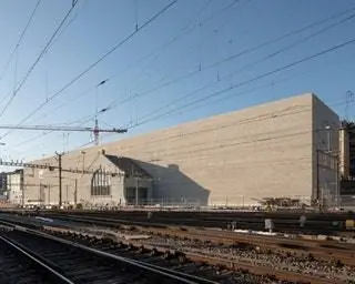 Сооружение длиной 145 метров имеет монолитный фасад со стороны железной дороги, функциональный ответ на…