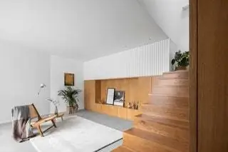 В гостиной «линия панелей из натурального дерева отмечает путь от входа к лестнице, которая в…