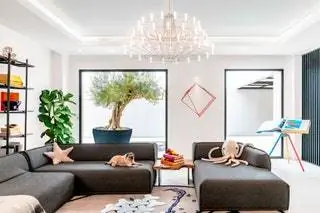В гостиной диван от Moroso, люстра от Moooi и скульптура на стене от Анны Барлик