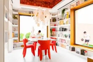 В библиотеке красные стулья от Moooi, а обои на потолке от House of Hackney
