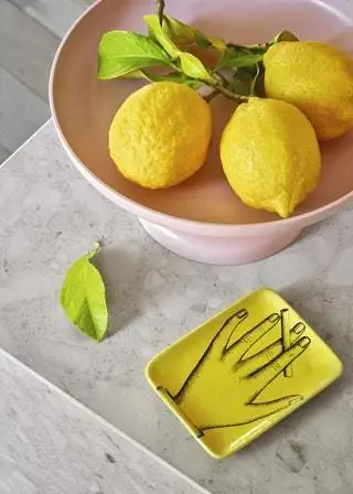 На столешнице розовая ваза для фруктов Tray от Джаспера Моррисона для Vitra и винтажная керамическая пепельница от Fornasetti. NBSP