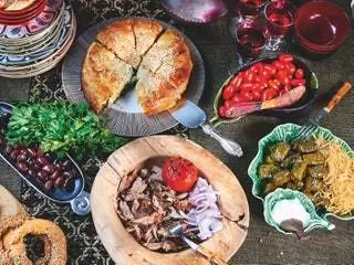 Традиционный греческий кулинарный стол, состоящий из шпинатного пирога Каламата, оливок, сувлаки и долмадакии