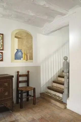 В начале лестницы под окном trompe l'oeil от Эльвиры Соланы деревянный стул и рогоз из 40-х годов и сирийский сундук из…