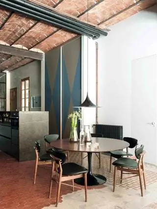 В столовой стол Tulip от Knoll, стулья от Finn Juhl и лампа от Gubi. На заднем плане кухня с системой Bulthaup B3…