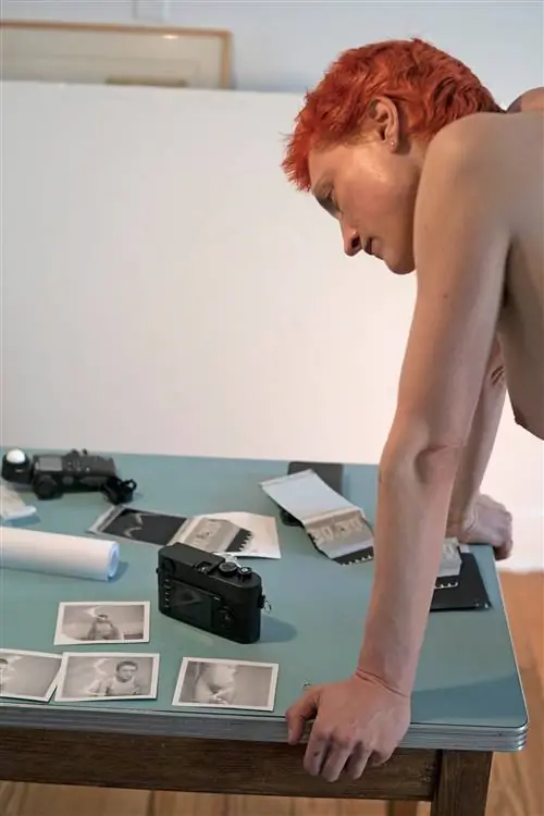 рыжеволосый мужчина смотрит на фотографии на столе