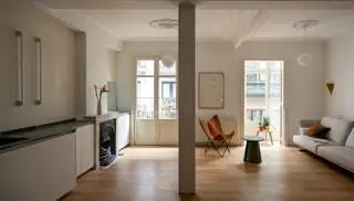 В гостиной кресло BFK от Knoll, приставной столик Cep от Teulat, диван от Joquer BCN и подвесной светильник Oh от Linea light