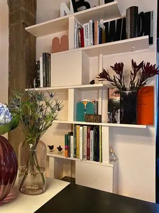 На этой сдержанной и функциональной полке стоят две подставки для книг Tortuga Dumbo бирюзового и розового цвета