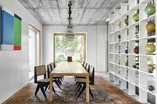В столовой дубовый стол от Artisan, оригинальные стулья Chandigarh от Pierre Jeanneret, изготовленные на заказ книжные полки…