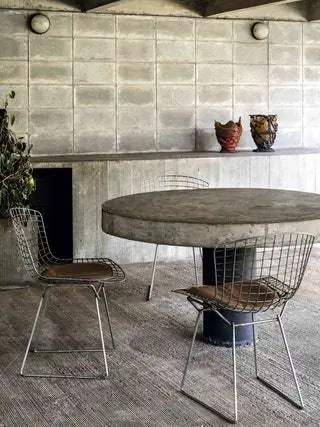 На крыльце стол архитектора со стульями Side от Гарри Бертойи для Knoll. На столешнице силиконовые вазы из…