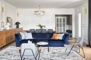 Главным героем гостиной является бархатный диван марки Natuzzi королевского синего цвета, состоящий из трех частей, которые можно…