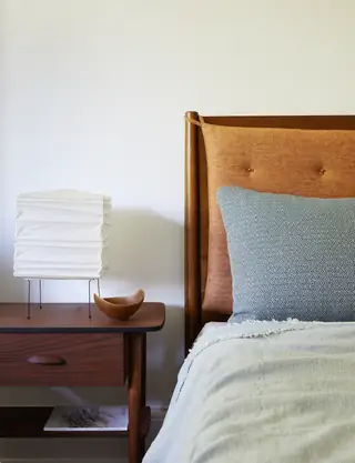 деревянный стол и кровать с изголовьем