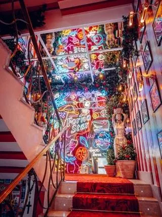 Красная дорожка с неоновыми огнями открывает вход в эту тратторию, о которой все уже говорят