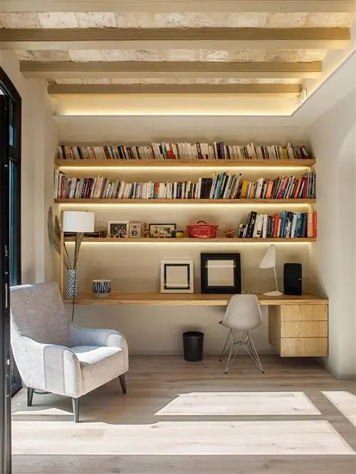 книжная полка с книгами белое кресло