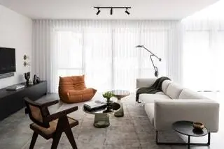 Оранжевое кресло Togo от Ligne Roset, разработанное Мишелем Дюкаруа, сочетается с винтажным стулом от Пьера Жаннере и…