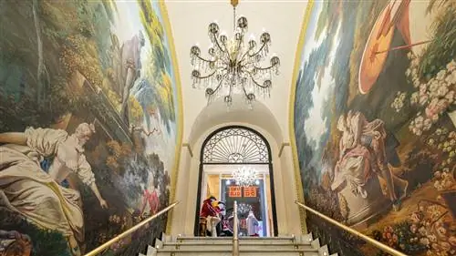 лестница с фресками с обеих сторон и позолоченными перилами