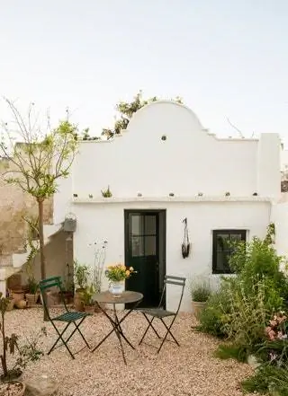 стол и стулья на фасаде белого дома