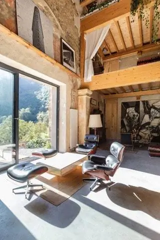 Жилая площадь с микроцементным полом и выходом на улицу. Пара шезлонгов Eames