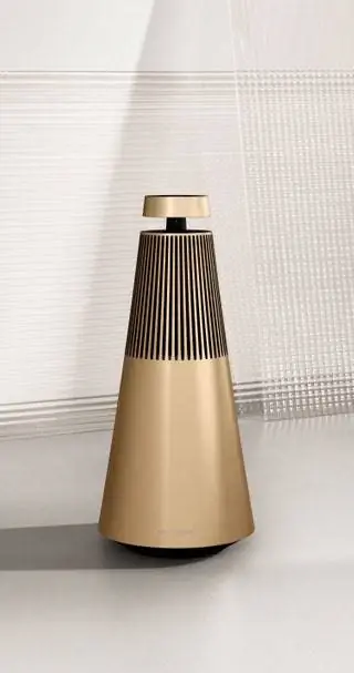 Громкоговоритель Beosound 2, известный своей конической формой, теперь имеет двухцветный алюминиевый корпус из анодированного золота…
