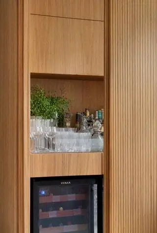 Деревянные панели в зоне для гурманов скрывают шкафы, которые можно передвигать, чтобы показать то, что нужно в любой момент…