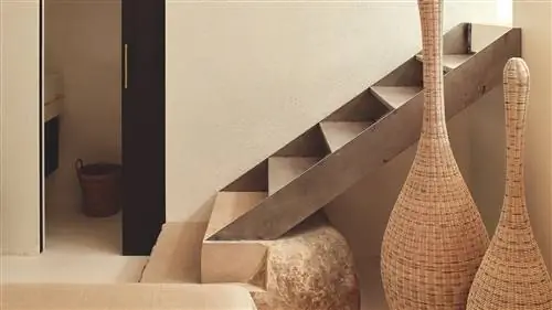 Светлый вход с металлической лестницей, элементами из ротанга и натуральными материалами, такими как камень и дерево