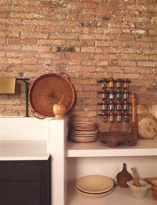 Деталь кухни квартиры в Сантс с кирпичной стеной и белой мебелью