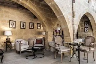 Грубая привозная древесина, камень, мягкие ткани и разноцветное дутое стекло занимают вход в отель, старый…