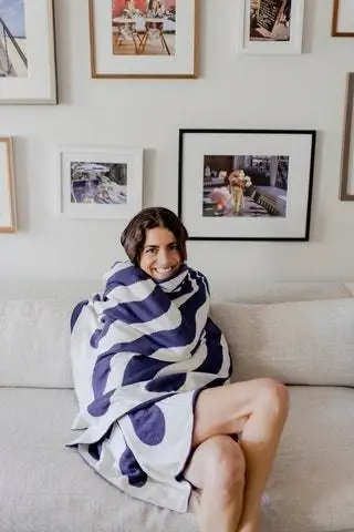 Леандра завернулась в свою другую любимую вещь Westwing - двустороннее одеяло Émile из органического хлопка