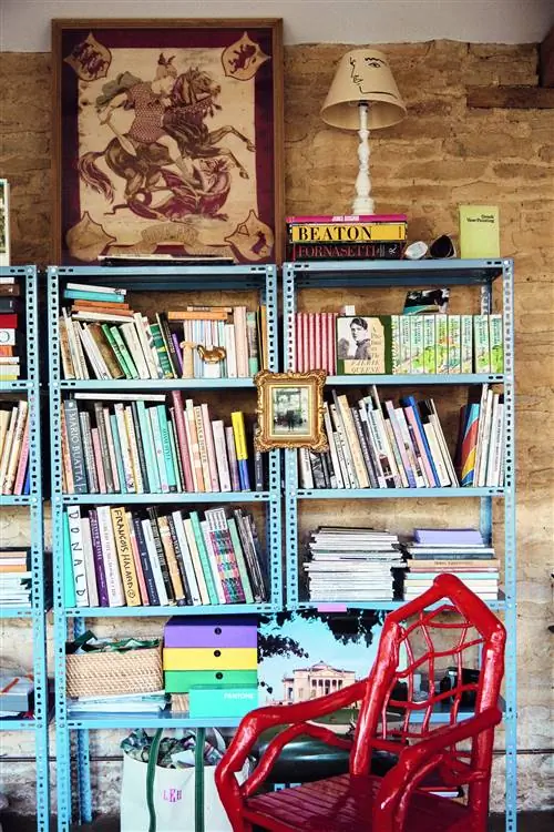 книжная полка с книгами и красным стулом