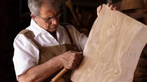 Ремесленник вручную обрабатывает кухонную деревянную доску