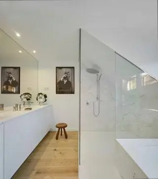 В основной ванной большое зеркало, занимающее всю стену, возвышается над тумбой с двумя раковинами