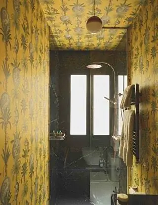 В ванной комнате обои Lemurs Mustard из коллекции Maximalism от Coordonné, лампа Dipping Light от Marset и…