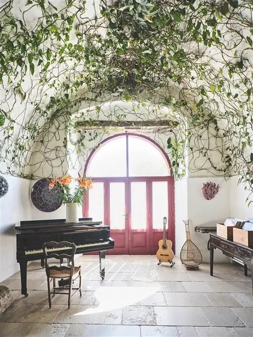 комната с роялем и дверью с аркой красного цвета