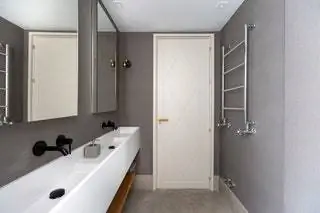 Выполнен в сером и белом цветах. Пол из серого известняка Silestone White Zeus Раковина Столешница и зеркальный ящик…