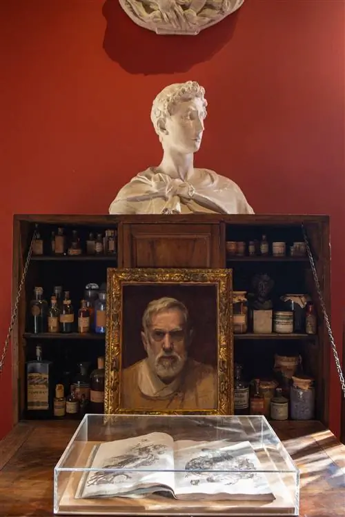 портретный бюст с позолоченной рамой и витриной с книгой