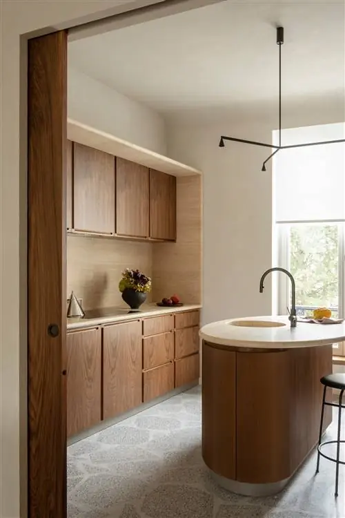 кухня с деревянным островом и темной мебелью