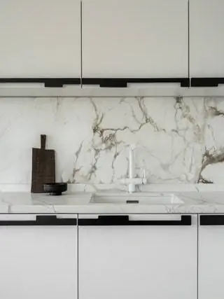 Для стен кухни был выбран белый мрамор с черными прожилками. Еще один штрих изысканности