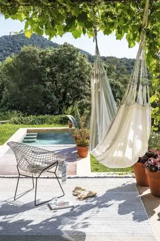 На крыльце коврики Tres из переработанного ПЭТ и Shade, а также гамак Wellbeing из хлопка и волокон крапивы от Ilse Crawford…