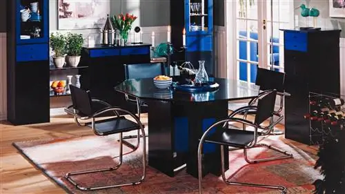интерьер столовой, оформленный мебелью от BoConcept в голубых тонах. На полу традиционный красноватый ковер