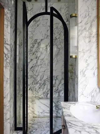 Основная ванная комната отделана мрамором Arabescato и ограждена железом и стеклом. Оригинальный настенный светильник BTC