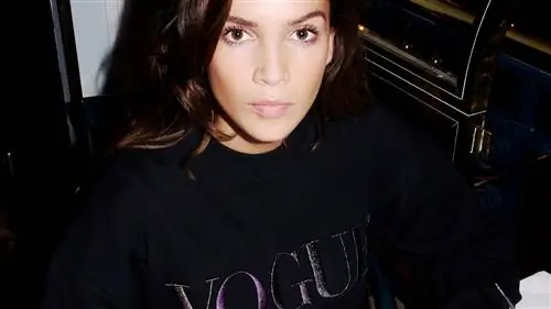 девушка в модной толстовке сидит за столом